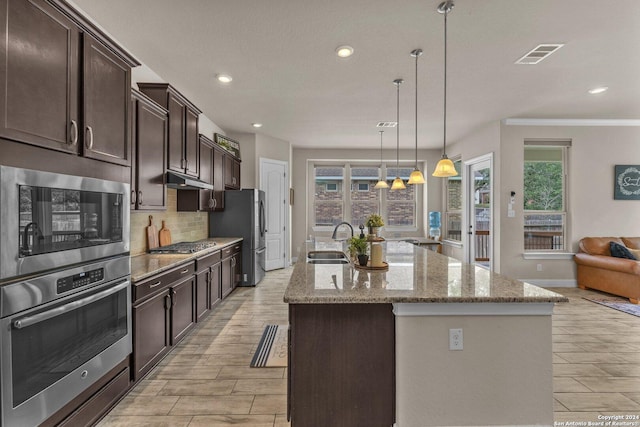 11926 Tower Crk, San Antonio, TX 78253 - kitchen with stainless steel appliances, a sink, dark brown cabinets, decorative backsplash, and a kitchen island with sink