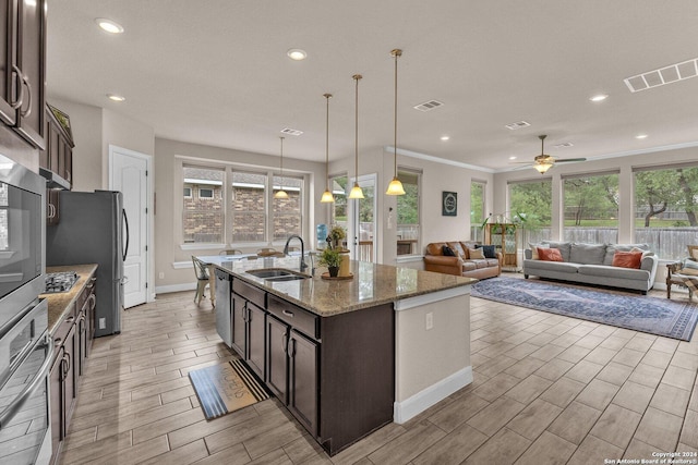 11926 Tower Crk, San Antonio, TX 78253 - kitchen featuring a sink, appliances with stainless steel finishes, dark brown cabinetry, wood tiled floors, and healthy amount of natural light
