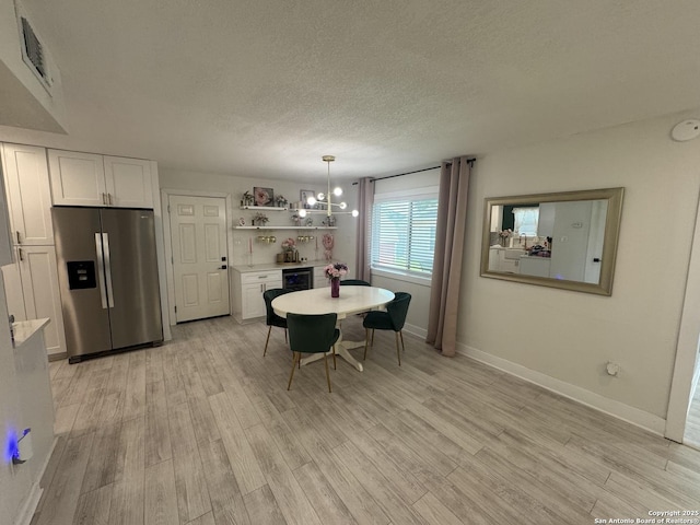 430 Indigo, San Antonio, TX 78216 - dining room with light wood finished floors, a textured ceiling, baseboards, and beverage cooler