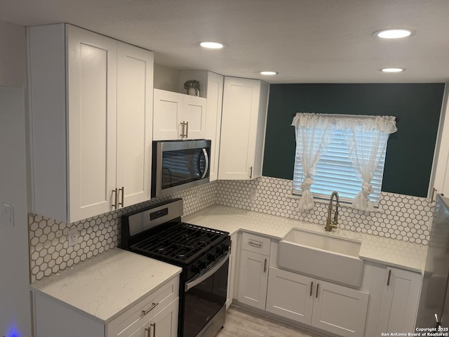 430 Indigo, San Antonio, TX 78216 - kitchen with appliances with stainless steel finishes, a sink, backsplash, white cabinetry, and recessed lighting