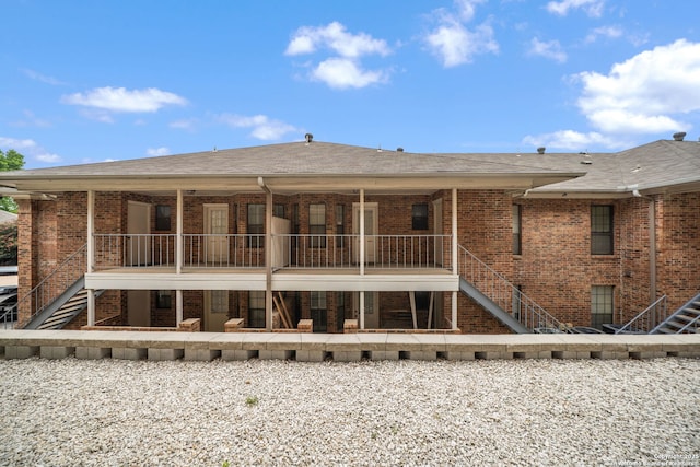 5359 Fredericksburg Unit 513, San Antonio, TX 78229 - rear view of property featuring stairs, brick siding, and a shingled roof