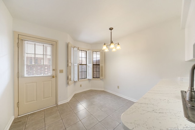 5359 Fredericksburg Unit 513, San Antonio, TX 78229 - unfurnished dining area with a chandelier, light tile patterned flooring, and baseboards