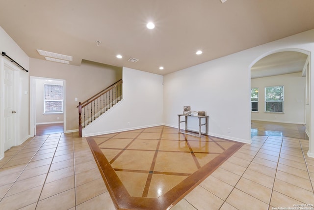 1711 Mountain, San Antonio, TX 78258 - foyer entrance featuring a barn door, arched walkways, light tile patterned floors, recessed lighting, and stairs