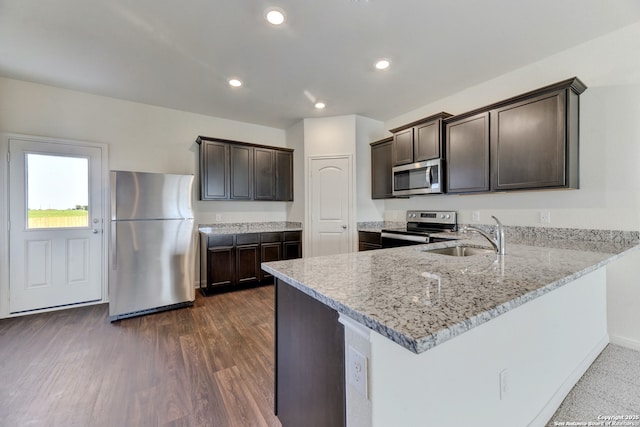 3139 Jackson Smt, Converse, TX 78109 - kitchen with appliances with stainless steel finishes, dark brown cabinets, light stone countertops, a peninsula, and recessed lighting