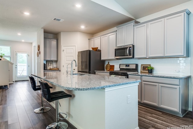 12918 Lilly Pass, San Antonio, TX 78254 - kitchen with appliances with stainless steel finishes, gray cabinets, dark wood-style flooring, backsplash, and light stone countertops