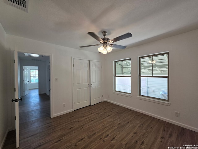 124 Baylor, San Antonio, TX 78204 - unfurnished bedroom with dark wood-style floors, baseboards, a closet, and a ceiling fan