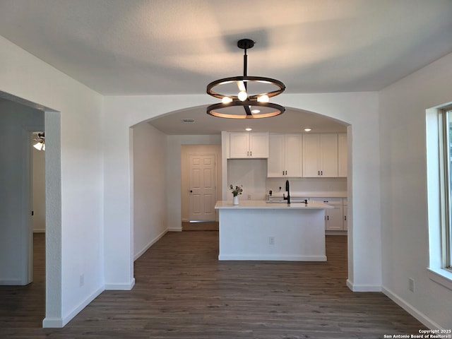 124 Baylor, San Antonio, TX 78204 - kitchen with arched walkways, white cabinets, dark wood-type flooring, and baseboards