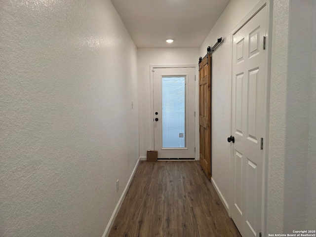 124 Baylor, San Antonio, TX 78204 - hallway featuring baseboards, dark wood finished floors, a barn door, and a textured wall