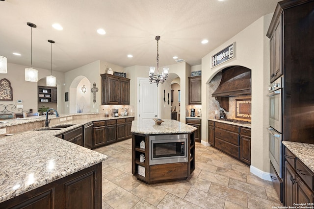 136 Eagle Crst, Spring Branch, TX 78070 - kitchen featuring appliances with stainless steel finishes, a sink, arched walkways, decorative backsplash, and dark brown cabinetry