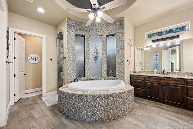 136 Eagle Crst, Spring Branch, TX 78070 - bathroom featuring a garden tub, vanity, ceiling fan, walk in shower, and wood finished floors