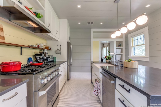 1007AND1013 Fulton, San Antonio, TX 78201 - kitchen with stainless steel appliances, dark countertops, open shelves, white cabinetry, and wall chimney range hood