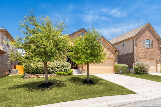27418 Camellia Trce, Boerne, TX 78015 - view of property hidden behind natural elements featuring brick siding, concrete driveway, a front yard, and a garage