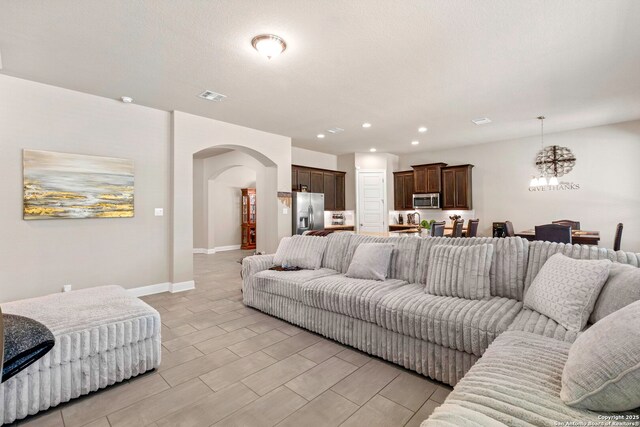 27418 Camellia Trce, Boerne, TX 78015 - living room with arched walkways, a chandelier, and recessed lighting
