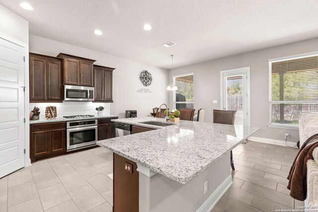27418 Camellia Trce, Boerne, TX 78015 - kitchen with appliances with stainless steel finishes, healthy amount of natural light, light stone countertops, backsplash, and recessed lighting