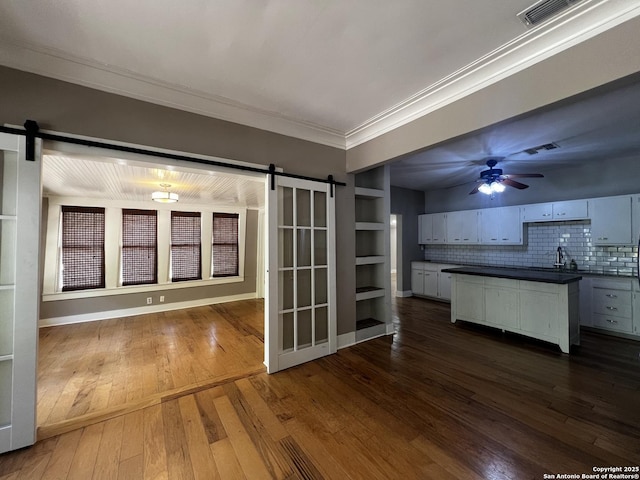 1024 W Mistletoe, San Antonio, TX 78201 - kitchen featuring a barn door, dark countertops, crown molding, dark wood-type flooring, and ceiling fan