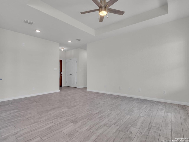 14329 Wisdom, Atascosa, TX 78002 - unfurnished room featuring light wood finished floors, a tray ceiling, ceiling fan, baseboards, and recessed lighting