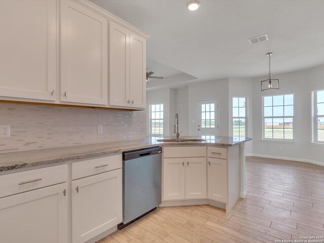 14329 Wisdom, Atascosa, TX 78002 - kitchen featuring stainless steel dishwasher, a sink, backsplash, white cabinets, and a peninsula