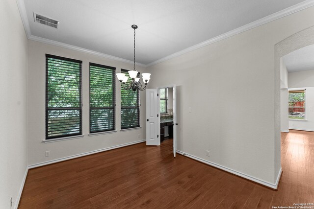 26011 Red Heron, San Antonio, TX 78261 - unfurnished dining area with a chandelier, wood finished floors, ornamental molding, arched walkways, and baseboards