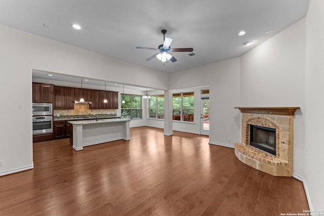 26011 Red Heron, San Antonio, TX 78261 - unfurnished living room featuring ceiling fan, a sink, dark wood-style floors, a fireplace, and recessed lighting