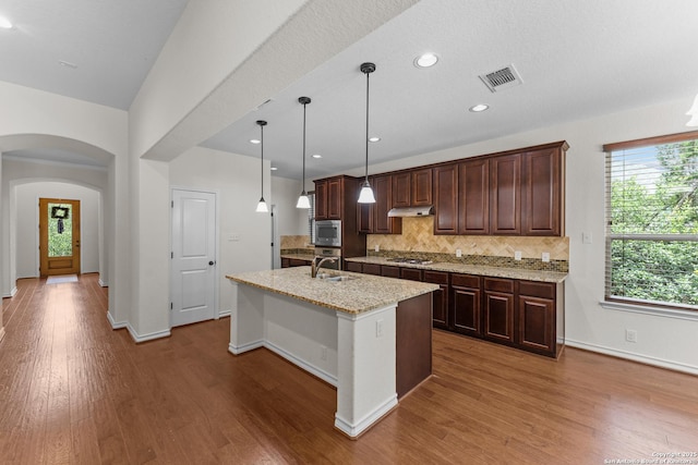 26011 Red Heron, San Antonio, TX 78261 - kitchen featuring backsplash, plenty of natural light, stainless steel microwave, under cabinet range hood, and recessed lighting