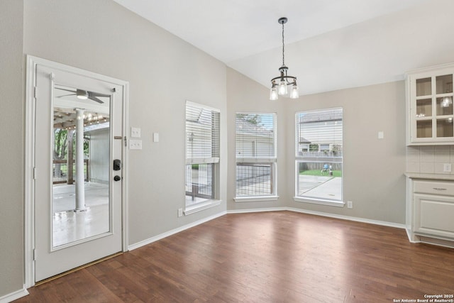 251 Las Brisas, Seguin, TX 78155 - unfurnished dining area with a chandelier, dark wood-style flooring, vaulted ceiling, baseboards, and a ceiling fan