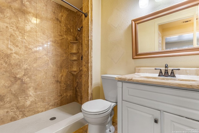 165 W Rampart Unit 204, San Antonio, TX 78216 - bathroom featuring vanity, toilet, a tile shower, and a textured wall