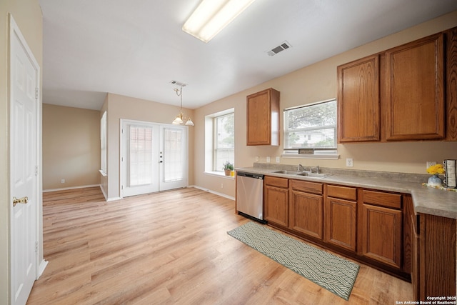 9026 Foxgrove Way, San Antonio, TX 78251 - kitchen featuring stainless steel dishwasher, brown cabinets, a sink, and light wood-style floors