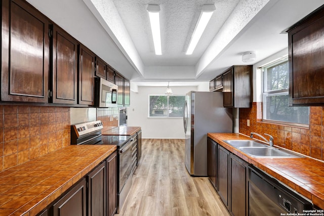 5810 Sky Country, San Antonio, TX 78247 - kitchen with appliances with stainless steel finishes, a sink, dark brown cabinetry, and a textured ceiling