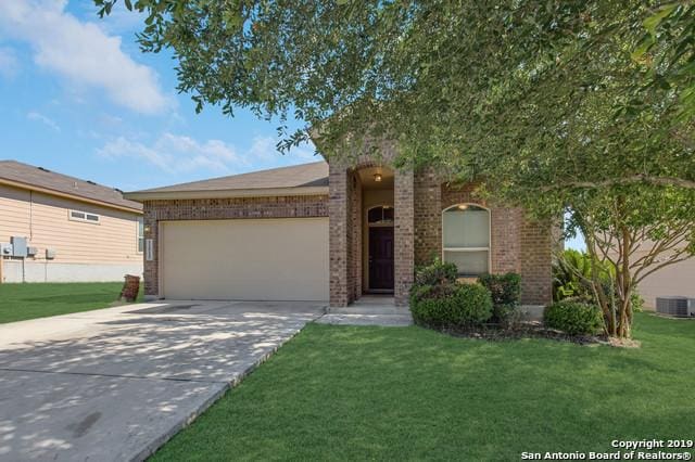 11515 Wayward Daisy, San Antonio, TX 78245 - view of front of home featuring a garage, brick siding, concrete driveway, and a front yard