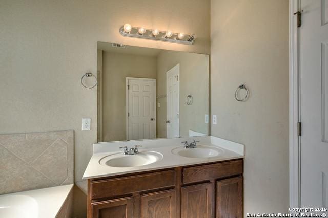 11515 Wayward Daisy, San Antonio, TX 78245 - bathroom featuring double vanity and a bath