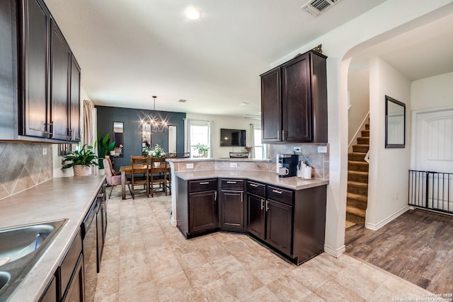 3006 Mission Bell, San Antonio, TX 78224 - kitchen featuring dark brown cabinetry, backsplash, a peninsula, a chandelier, and light countertops