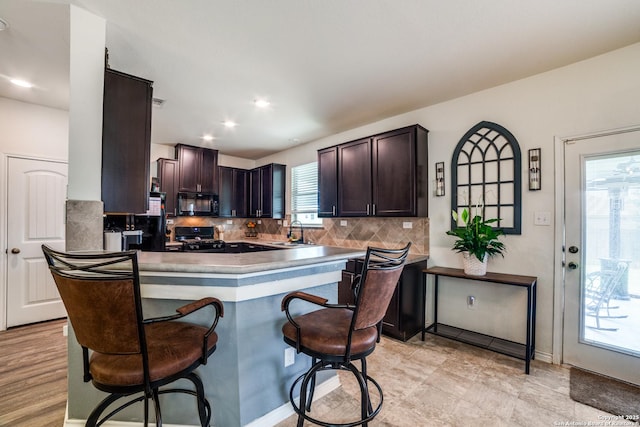3006 Mission Bell, San Antonio, TX 78224 - kitchen with black appliances, a sink, dark brown cabinets, decorative backsplash, and recessed lighting