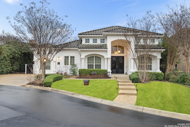 24706 Moorland, San Antonio, TX 78257 - mediterranean / spanish house featuring french doors, a tile roof, stucco siding, a front yard, and driveway