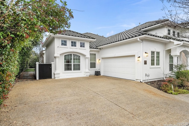 24706 Moorland, San Antonio, TX 78257 - mediterranean / spanish house featuring an attached garage, a tiled roof, concrete driveway, stucco siding, and a gate