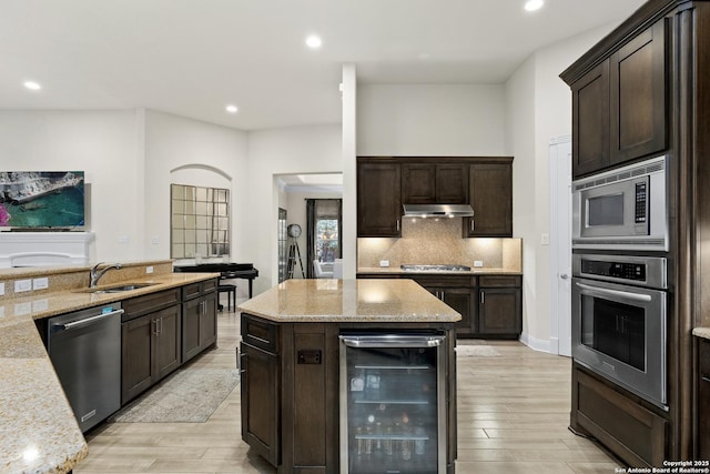 24706 Moorland, San Antonio, TX 78257 - kitchen with beverage cooler, appliances with stainless steel finishes, a sink, under cabinet range hood, and dark brown cabinets