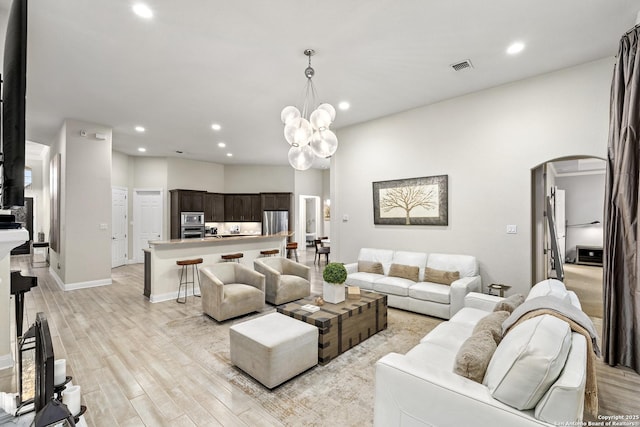 24706 Moorland, San Antonio, TX 78257 - living room featuring arched walkways, recessed lighting, light wood-style flooring, baseboards, and a chandelier
