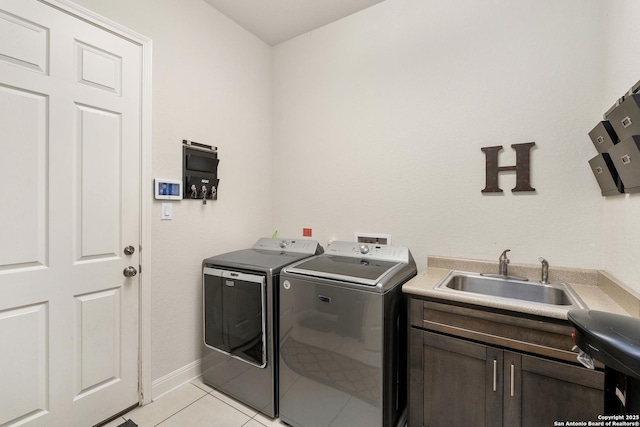 24706 Moorland, San Antonio, TX 78257 - laundry area featuring washing machine and clothes dryer, cabinet space, light tile patterned flooring, and baseboards