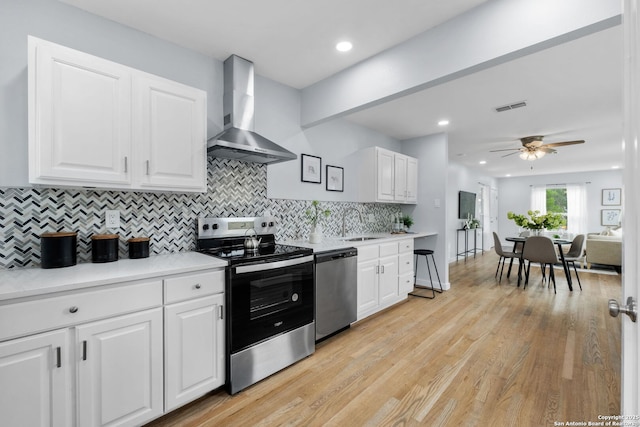 131 New Hvn, San Antonio, TX 78209 - kitchen with stainless steel appliances, wall chimney exhaust hood, a sink, decorative backsplash, and light countertops