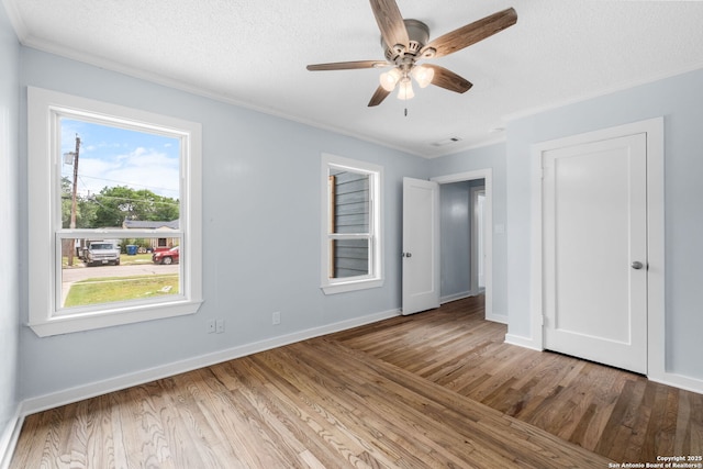 131 New Hvn, San Antonio, TX 78209 - unfurnished bedroom featuring crown molding, wood finished floors, baseboards, ceiling fan, and a textured ceiling