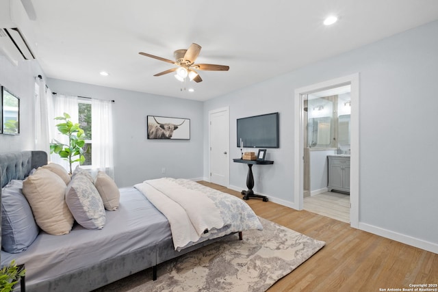 131 New Hvn, San Antonio, TX 78209 - bedroom featuring a wall mounted air conditioner, light wood-style floors, baseboards, recessed lighting, and ensuite bath