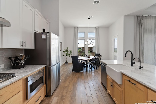 1512 Aubrey Pt, San Antonio, TX 78260 - kitchen featuring a sink, stainless steel appliances, backsplash, light wood-style floors, and light stone countertops