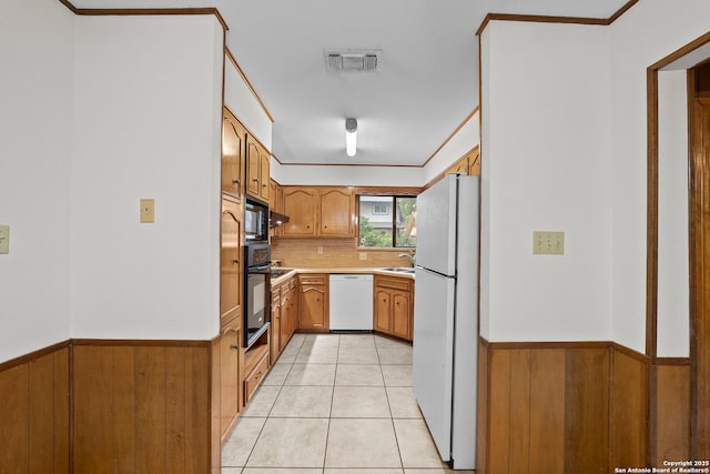 9219 George Kyle St, San Antonio, TX 78240 - kitchen featuring black appliances, light countertops, wainscoting, backsplash, and light tile patterned flooring