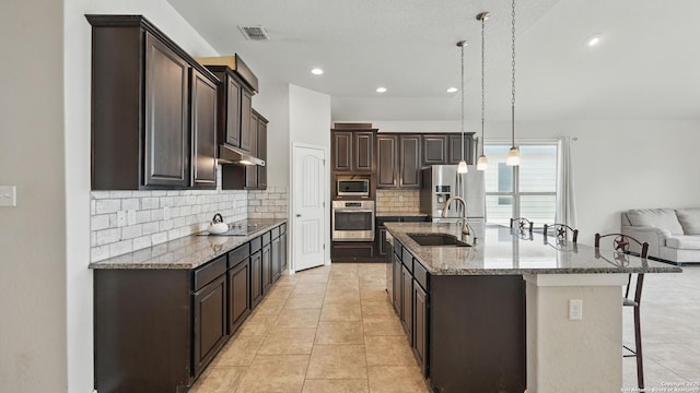 3542 Hurricane, New Braunfels, TX 78130 - kitchen featuring appliances with stainless steel finishes, a sink, dark brown cabinets, a breakfast bar, and backsplash