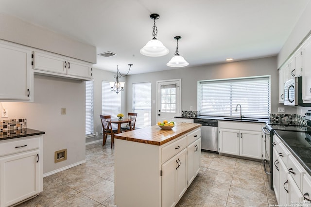 18039 Shady Knl, San Antonio, TX 78258 - kitchen with appliances with stainless steel finishes, a sink, tasteful backsplash, white cabinets, and butcher block counters
