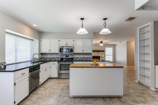 18039 Shady Knl, San Antonio, TX 78258 - kitchen with stainless steel appliances, a sink, butcher block countertops, ceiling fan, and white cabinets