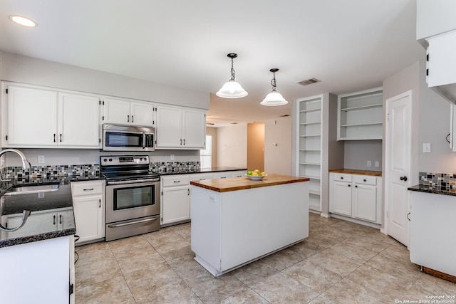 18039 Shady Knl, San Antonio, TX 78258 - kitchen with stainless steel appliances, a sink, butcher block counters, white cabinets, and a center island