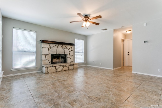 18039 Shady Knl, San Antonio, TX 78258 - unfurnished living room featuring a ceiling fan, a stone fireplace, tile patterned floors, and baseboards