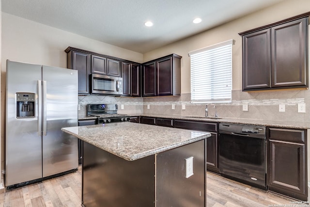 1614 Desert Candle, San Antonio, TX 78245 - kitchen featuring black appliances, dark brown cabinetry, a kitchen island, light wood-type flooring, and recessed lighting