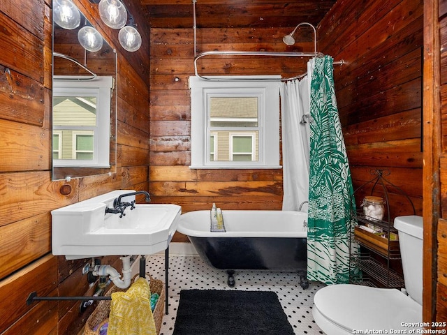 211 W High Ave, San Antonio, TX 78210 - bathroom featuring toilet, a freestanding bath, wood walls, a sink, and curtained shower