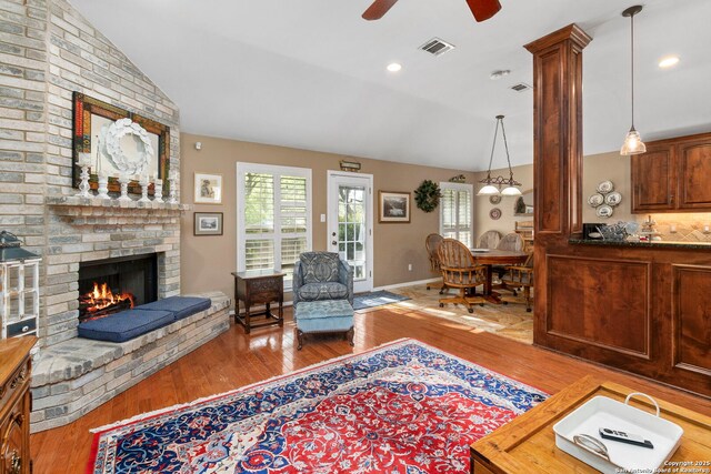8826 Lost Bnd, San Antonio, TX 78240 - living area with lofted ceiling, wood finished floors, healthy amount of natural light, a fireplace, and a ceiling fan
